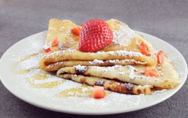 Bir plaka üzerinde çilek ile iki gözleme.