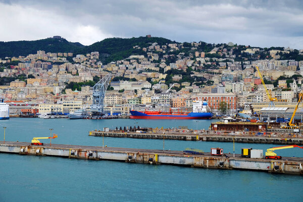 View on the port with ships and boats and the architecture of Genoa.