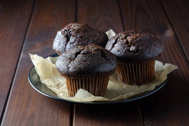 Karanlık bir arka plan üzerinde bir tabakta çikolatalı kek.