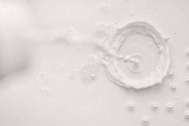 Beyaz arka planda incili süt damlası.