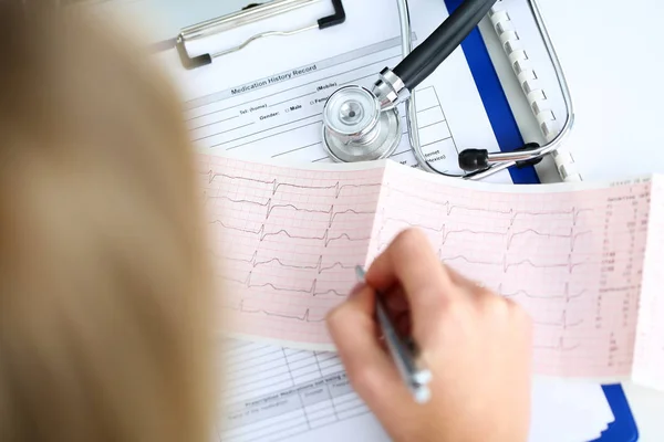 Manos del médico con cardiograma gráfico en el portapapeles —  Fotos de Stock