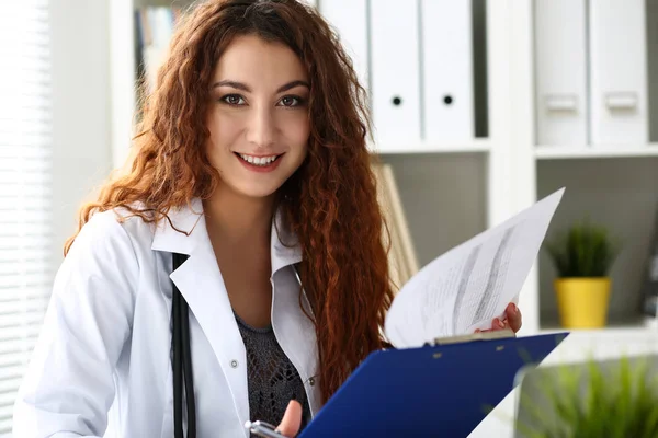 Hermosa sonriente médico femenino sujetar portapapeles — Foto de Stock