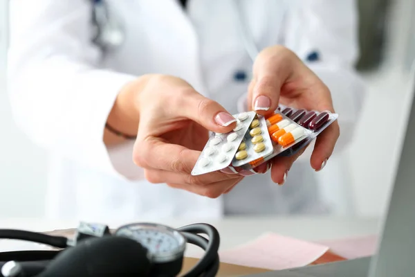 Hand van de vrouwelijke arts met pack van verschillende tablet blaren — Stockfoto
