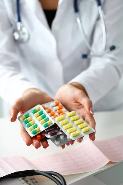 Ärztin hält Packung mit verschiedenen Tablettenblasen in der Hand — Stockfoto