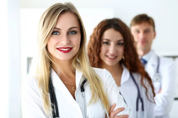 Grupo de médicos posando orgullosamente en fila y mirando a la cámara — Foto de Stock