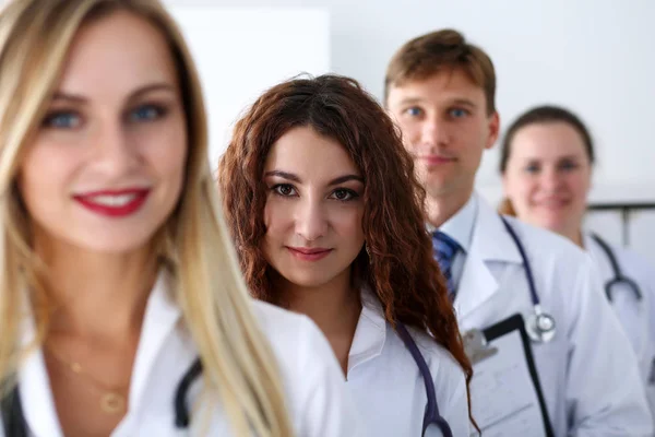 Grupo de médicos orgulhosamente posando em linha e olhando na câmera smil — Fotografia de Stock