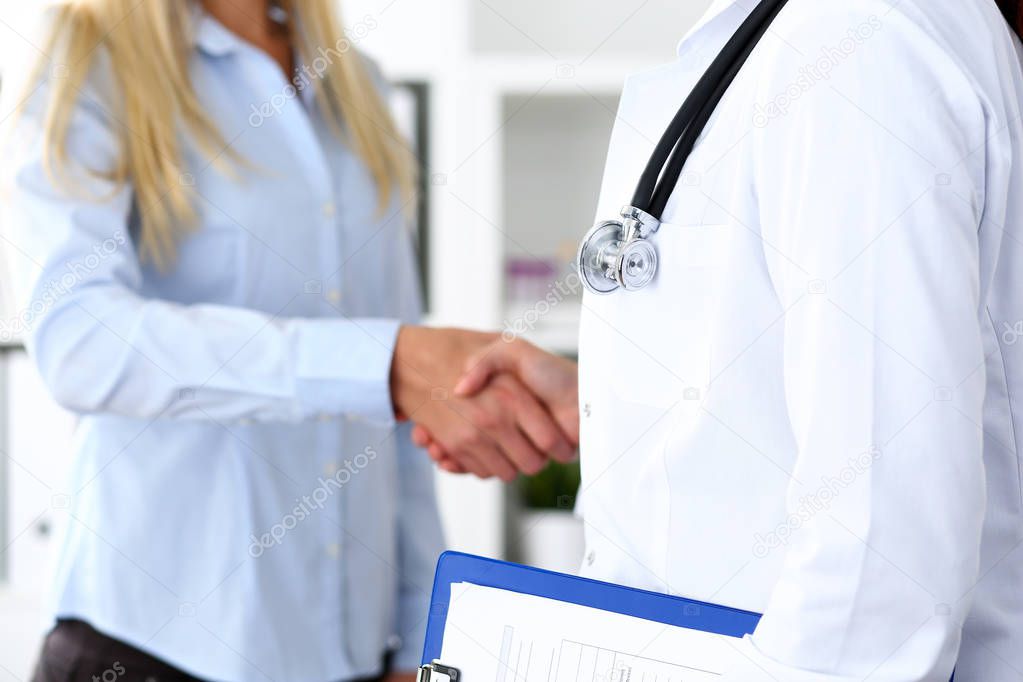 Female medicine doctor shake hand as hello with businesswoman in