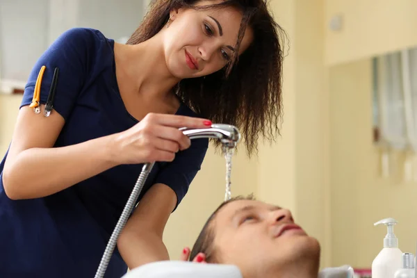 Жінка миє волосся до красивого усміхненого чоловіка — стокове фото