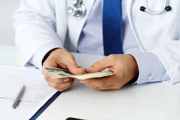 Male medicine doctor holding in hands bunch of hundred dollars b — Stock Photo, Image