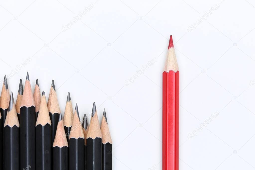 Red pencil standing out from crowd of plenty identical black fel