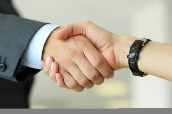 Businessman and woman shake hands as hello in office closeup