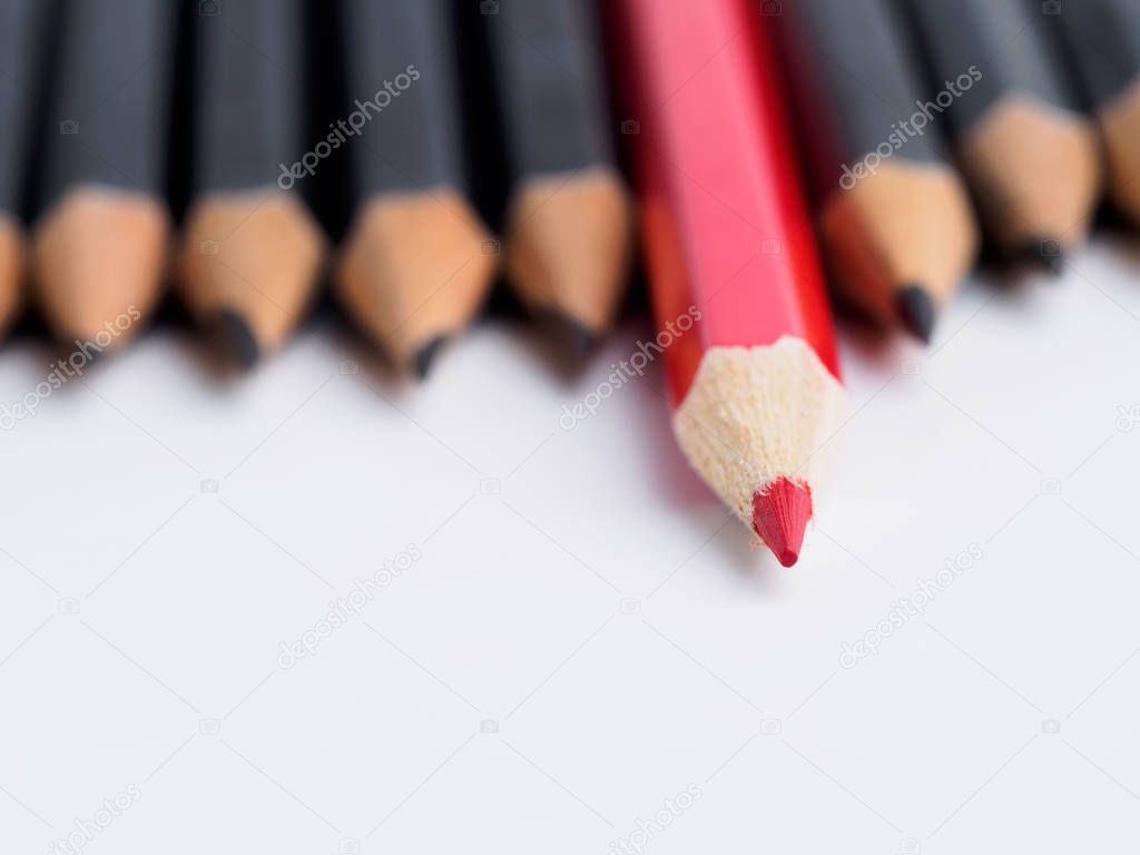 Red pencil standing out from crowd of plenty identical fellows
