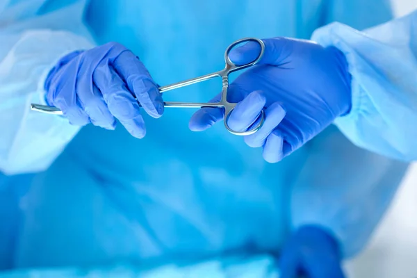 Surgeons hands holding and passing surgical instrument to other — Stock Photo, Image