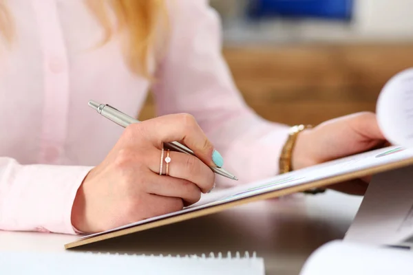 Female arms hold silver pen and pad — Stock Photo, Image