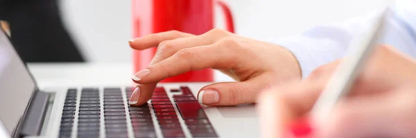 Hand of businesswoman press button at laptop computer