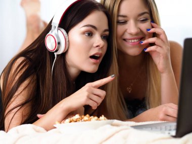 İki mutlu gülümseyen kız arkadaşım patlamış mısır yemek