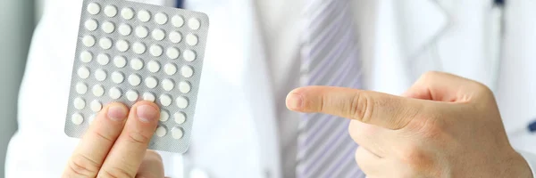 Gp zeigt mit dem Finger auf Blase voller weißer Tabletten — Stockfoto