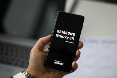 Samsung Galaksisi 11 'i tutan erkek kol.