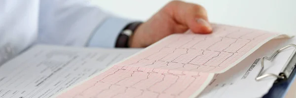 Male medicine doctor hands holding cardiogram chart — Stock Photo, Image