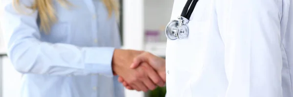 Female medicine doctor shake hand as hello with businesswoman in office closeup — Stock Photo, Image