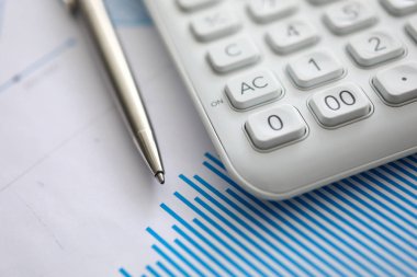 Kağıt üzerinde beyaz hesap makinesi ve gümüş kalem