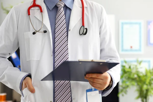 Stethoscope lying on male doctor chest in office — Stock Photo, Image