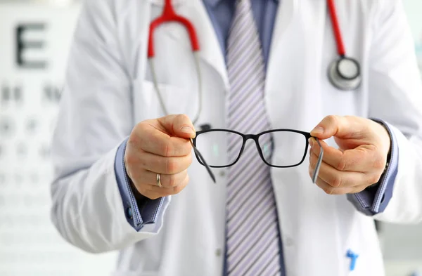 Male medicine doctor hands giving pair of black glasses — Stock Photo, Image