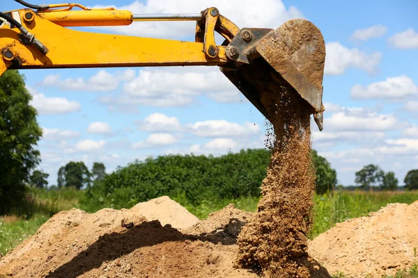 Żółty koparka łopata kopanie dół w ziemi — Zdjęcie stockowe
