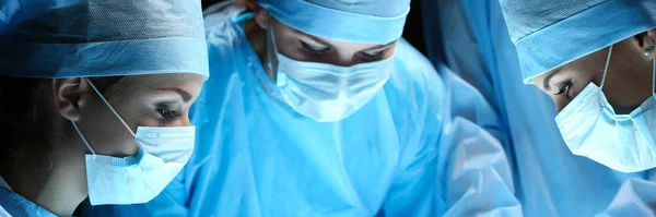 Grupa chirurgów w pracy działających w teatrze chirurgiczne — Zdjęcie stockowe