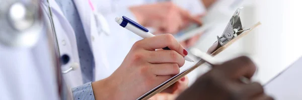 Gruppe von Ärzten hält Stifte und Klemmbretter in der Hand — Stockfoto