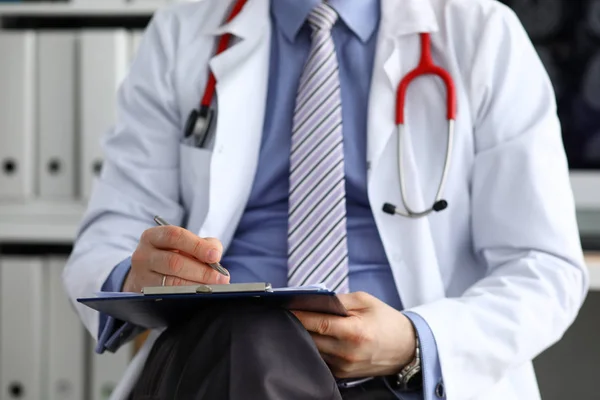 Médico masculino mano sosteniendo pluma de plata escritura — Foto de Stock