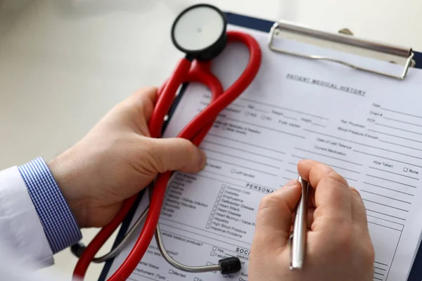 Médico masculino mano sosteniendo pluma de plata escritura —  Fotos de Stock