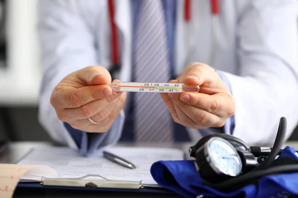 Manlig läkare som håller i handtermometer — Stockfoto