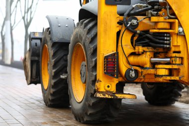 Asfaltta çalışmaya hazır kocaman sarı bir kürek.