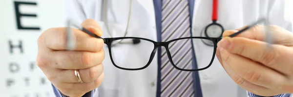 Hombre medicina doctor manos dando par de negro gafas —  Fotos de Stock