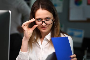 Kadın ofis çalışanı gözlüğü şakayla ayarlıyor