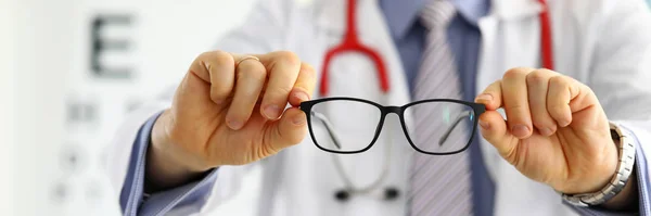 Male medicine doctor hands giving pair of black glasses — Stock Photo, Image