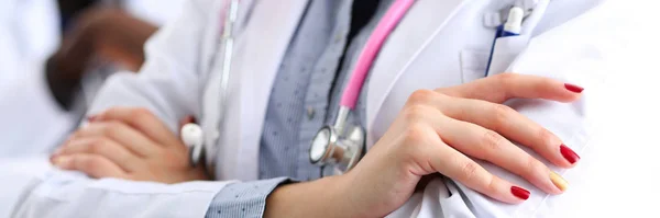 Médico femenino manos cruzadas en el pecho en el consultorio —  Fotos de Stock