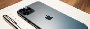 Iphone pro aygıtı açık dizüstü bilgisayarın önünde yatıyor
