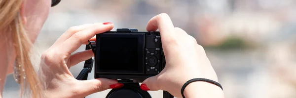 Mujer sosteniendo una pequeña cámara digital tratando de tomar fotos de viaje — Foto de Stock