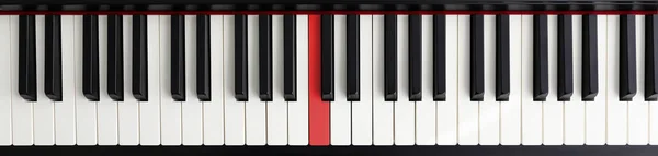 Пианино с красной клавишей — стоковое фото