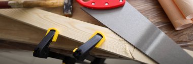 Carpenter hand tools and patterns lie on workbench