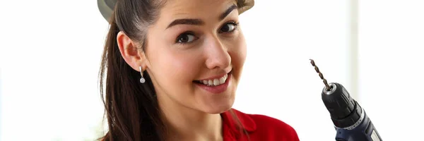 Retrato de jovem bela mulher morena segurando martelo e broca — Fotografia de Stock