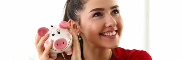 Portret van jonge mooie brunette vrouw met roze spaarpot voor geld — Stockfoto