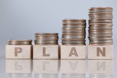 Gümüş çeyreklikler, tahta küplerin önünde duruyor.