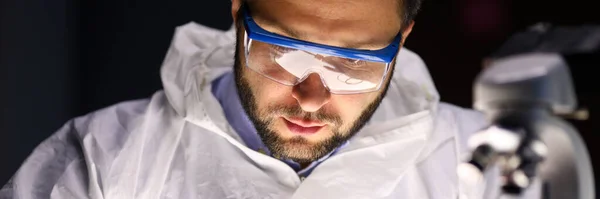 Человек лабораторный ремонт прибора вблизи микроскопа — стоковое фото