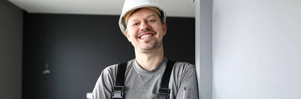 Young smiling repairman standing in empty flat and holding screwdriver in hands — ストック写真