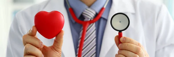 Medicina masculina médico segurando coração vermelho e estetoscópio — Fotografia de Stock
