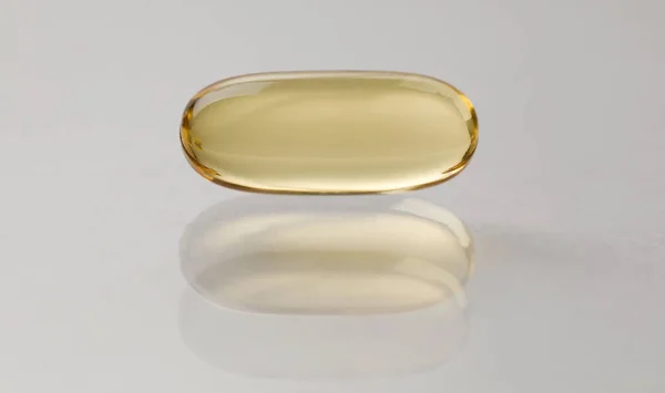 Source vitamins fish oil capsule lies on surface — Φωτογραφία Αρχείου