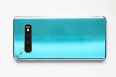 Modern smartphone lying at table with crack in corner